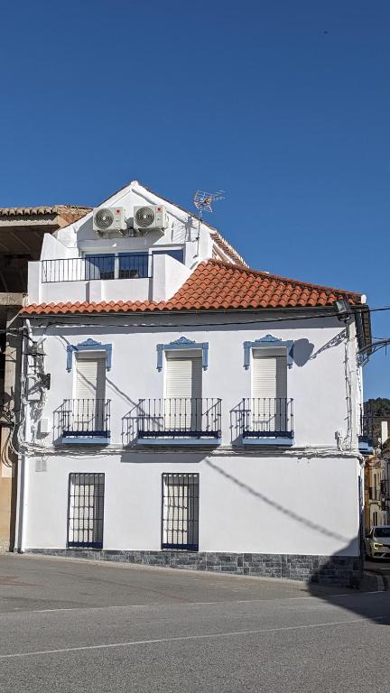 a white building with balconies on a street at Casa EntreAzules l Vivienda Rural in Lecrin