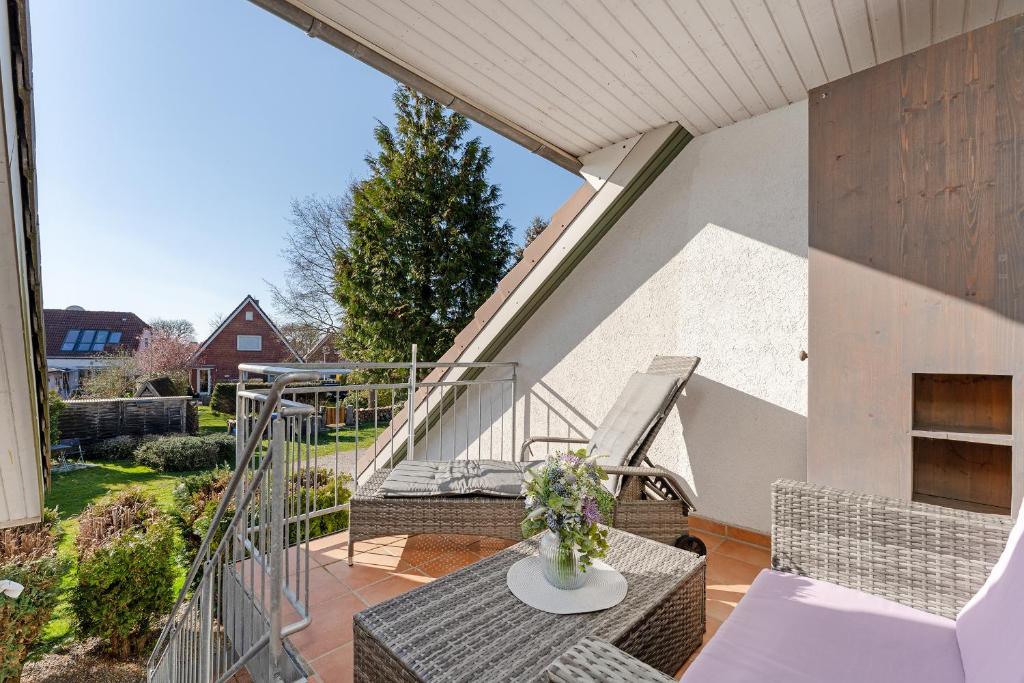 a balcony with wicker chairs and a table at Arne's Koje in Fehmarn