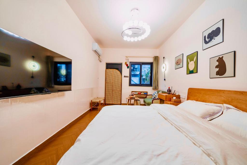 um quarto com uma grande cama branca em um quarto em 定安厝 Ding'an Village 位于百年历史建筑群 近西湖 河坊街 南宋御街 em Hangzhou