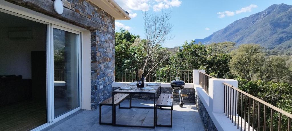un patio avec une table et des chaises sur un balcon dans l'établissement Villa Viktoriia, à San-Nicolao