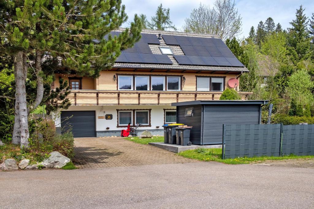 a house with solar panels on the roof at Ferienwohnung am Schwellenweiher in Feldberg