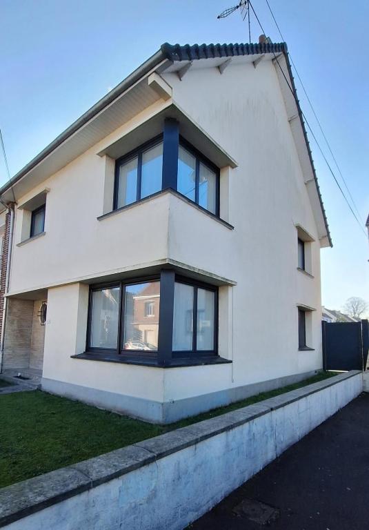 une maison blanche avec des fenêtres noires dans l'établissement Ô Charme de St Ô, à Saint-Omer