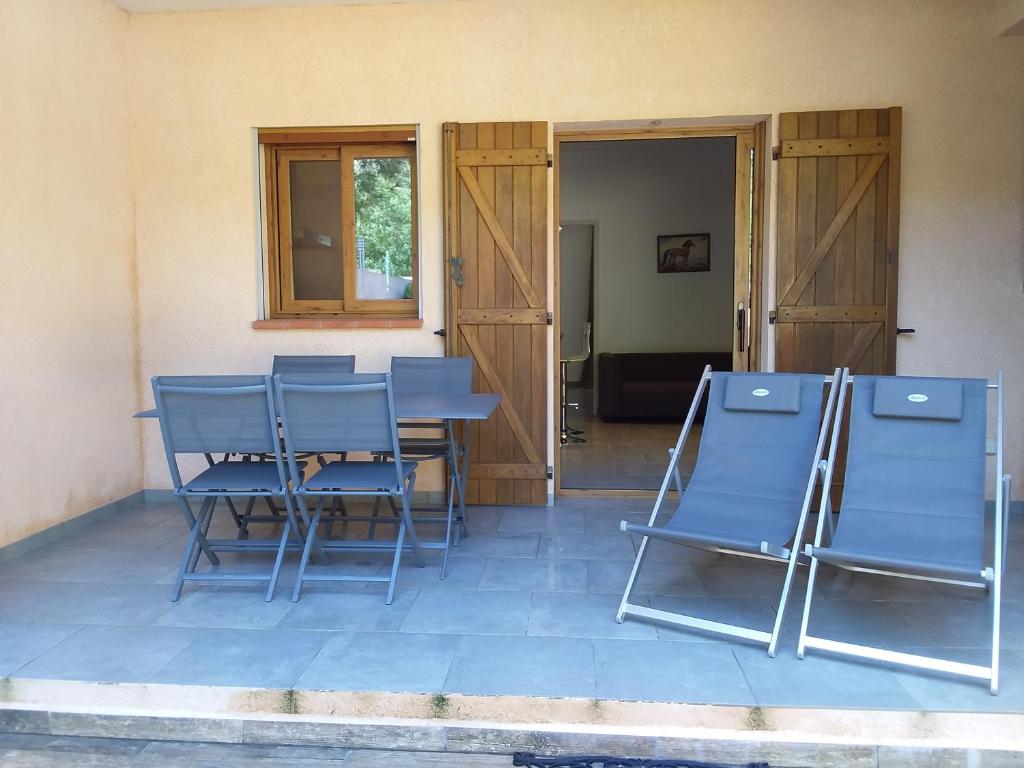 - un ensemble de chaises bleues assises sur une terrasse dans l'établissement jolie location, à Porto-Vecchio