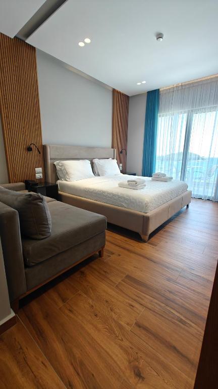 a large bedroom with a bed and a couch at King Hotel Ksamil in Ksamil