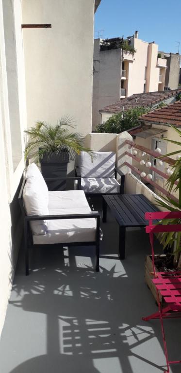 d'une terrasse avec un banc et une table sur un balcon. dans l'établissement Appartement centre-ville avec terrasse, à Montpellier