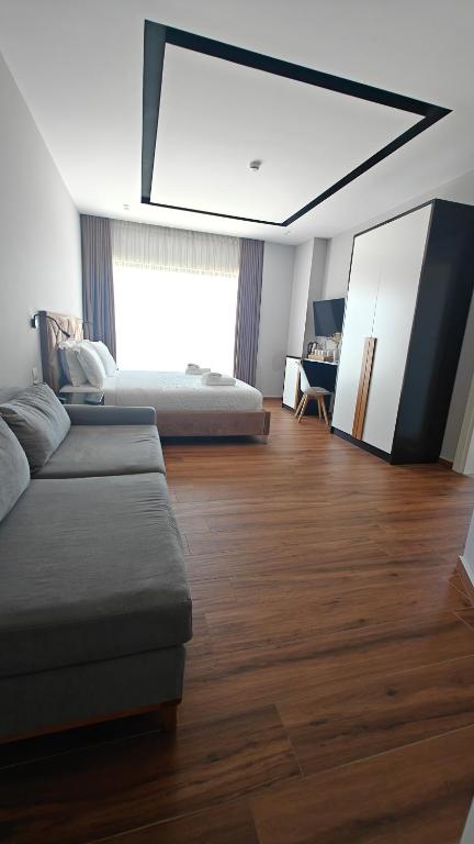 a room with two beds and a couch and a table at King Hotel Ksamil in Ksamil