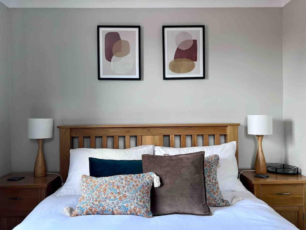 a bedroom with a bed with three pictures on the wall at Cosy Georgian Cottage - Parking - Central Frome in Frome