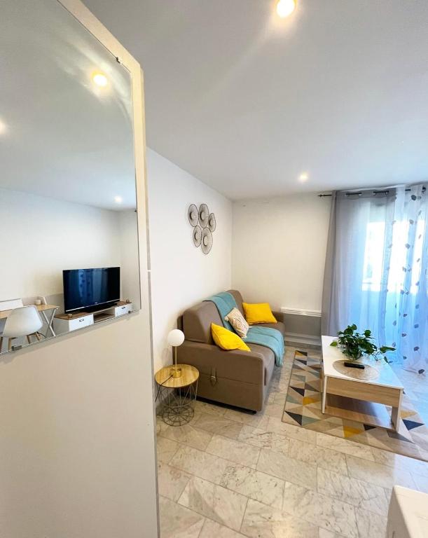 un salon avec un canapé et une télévision dans l'établissement Super studio bord de mer, promenade des anglais, à Nice