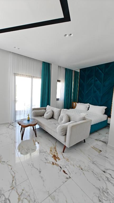 a living room with a white couch and a table at King Hotel Ksamil in Ksamil