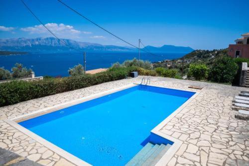 a blue swimming pool with a view of the water at Veranda Blue in Nikiana