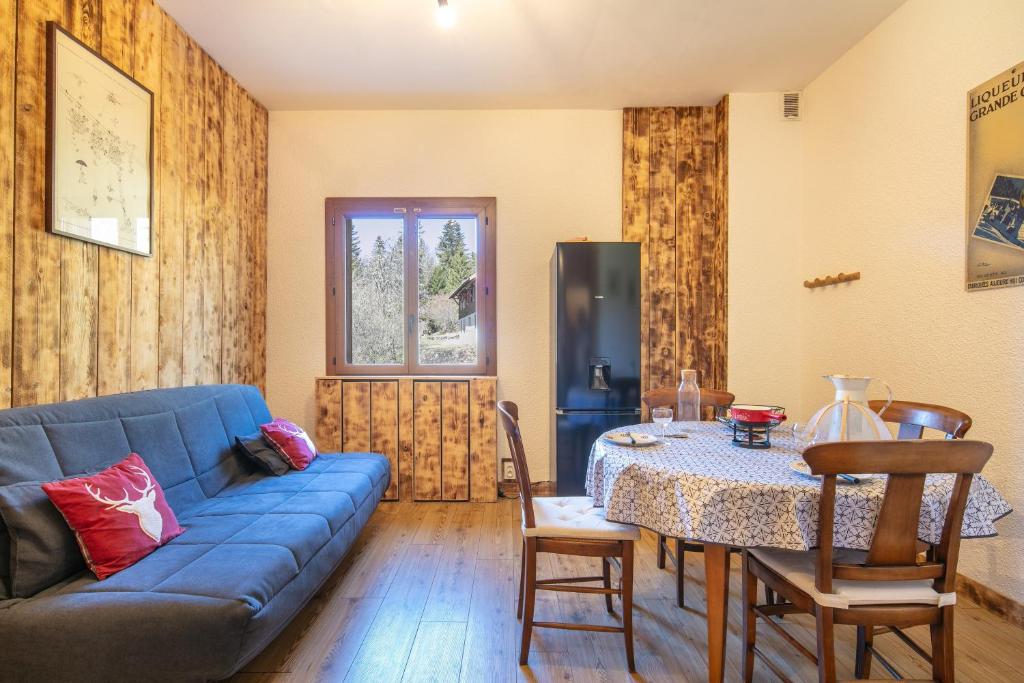 a living room with a blue couch and a table at Le Grand Som - Proche Station de ski in Saint-Pierre-de-Chartreuse
