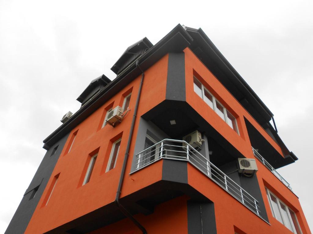 ein orangefarbenes Gebäude mit Balkon darüber in der Unterkunft Villa Angel Apartments - OHRID- in Ohrid