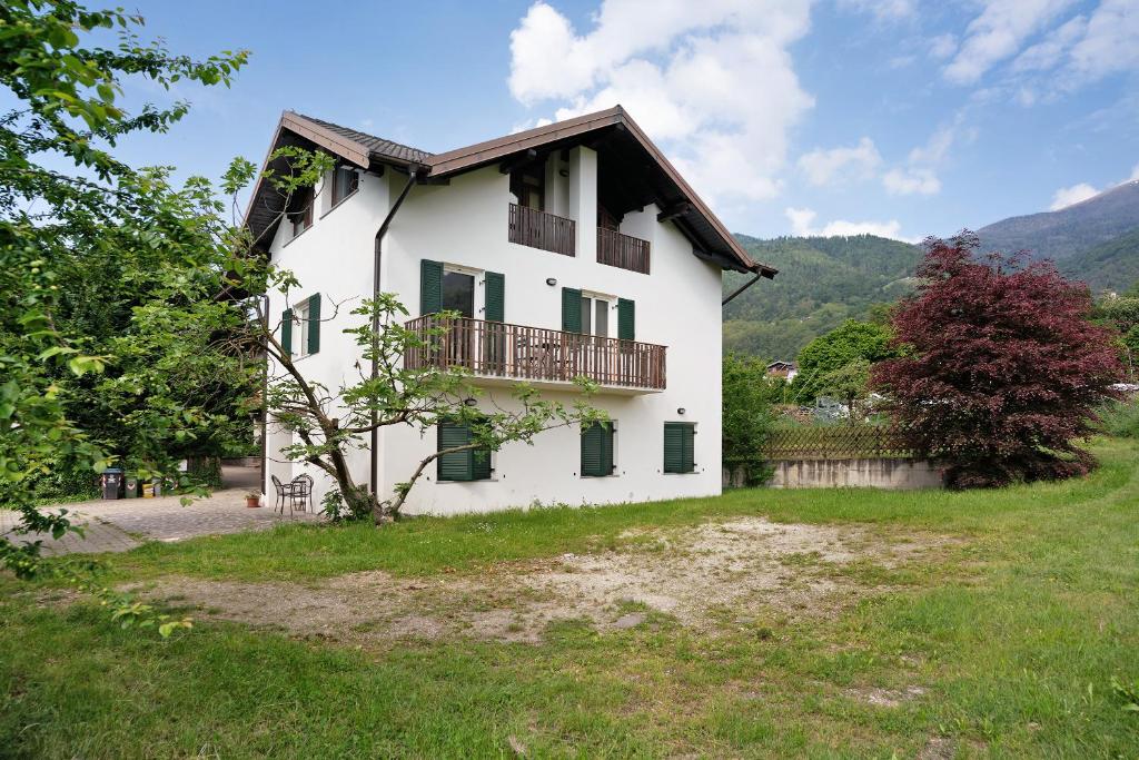 Casa blanca con balcón en un campo en Agritur Montibeller Fravort, en Marter di Roncegno