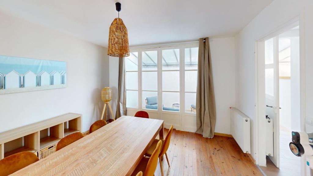 a dining room with a wooden table and a large window at Magnifique maison avec Jardin in Le Havre