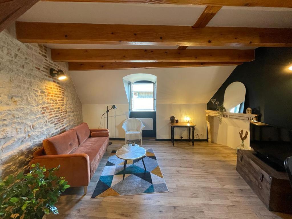 un salon avec un canapé et une table dans l'établissement Le Dolois, à Dole
