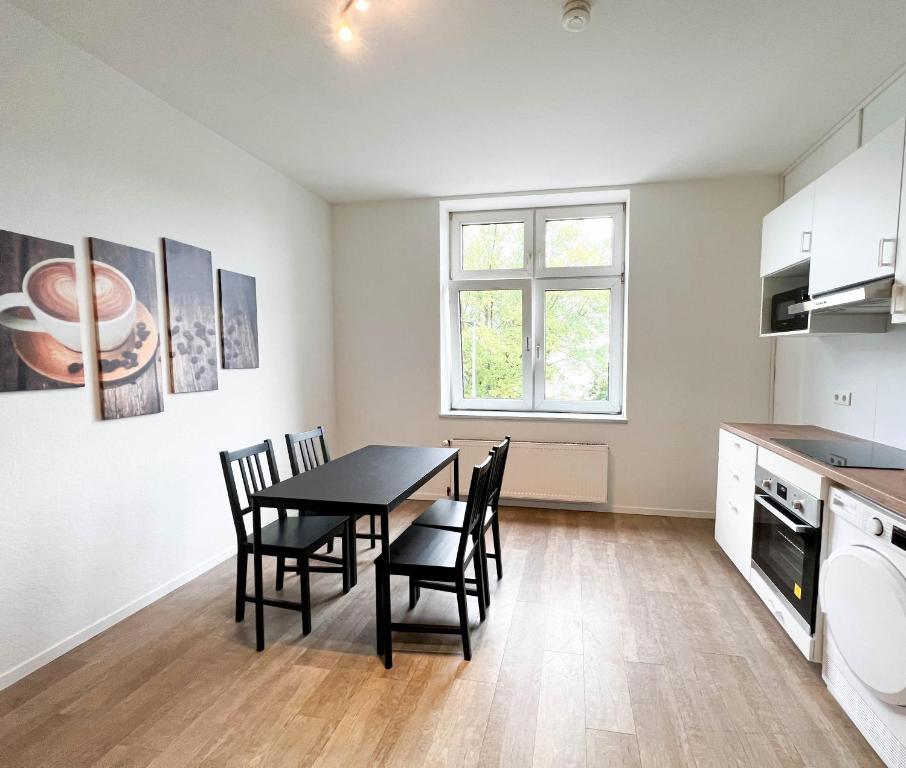 a kitchen with a dining room table and chairs at Key2Komfort in Duisburg