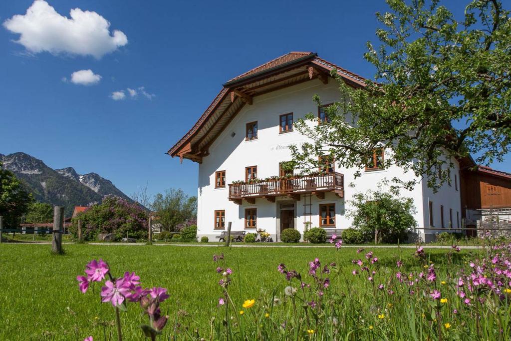 a large white house with a field of flowers at Ödmühle - Chiemgau Karte in Inzell