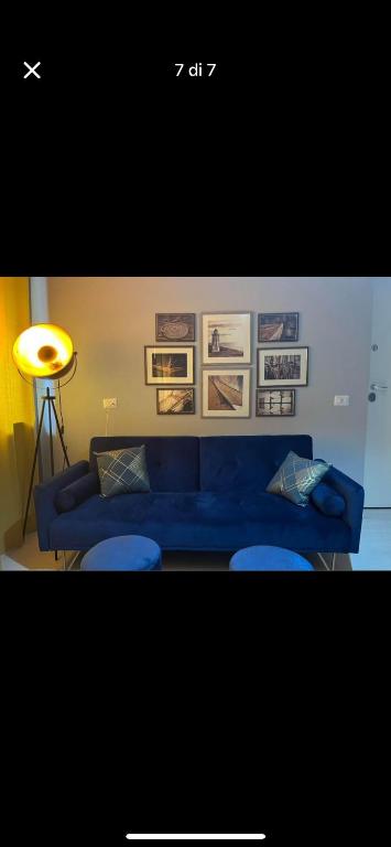 a living room with a blue couch and two stools at Luxro Home Crotone in Crotone