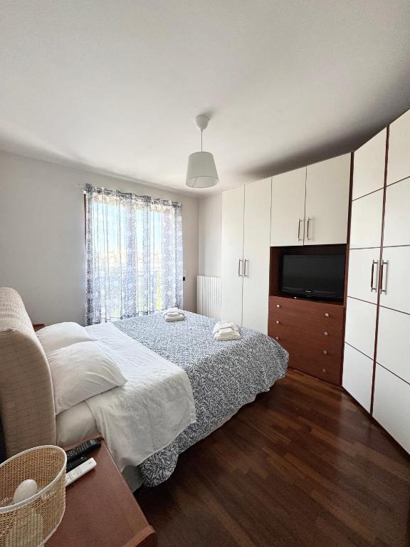 a bedroom with a bed and a flat screen tv at HomeAway Pescara Airport in San Giovanni Teatino