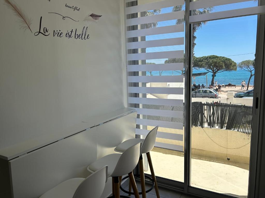 - une chambre avec des chaises et une vue sur la plage dans l'établissement Appartement bord de mer, à La Ciotat