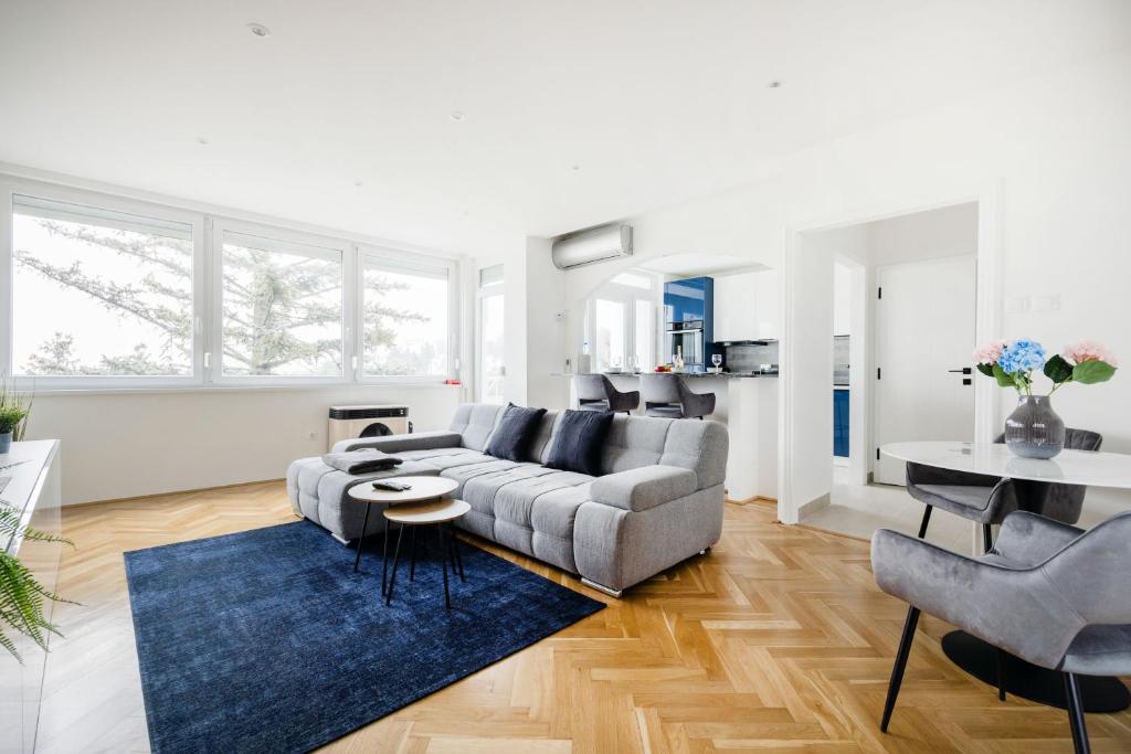 a living room with a couch and a blue rug at Tranquil Hideaway on Gellért Hill with Parking in Budapest