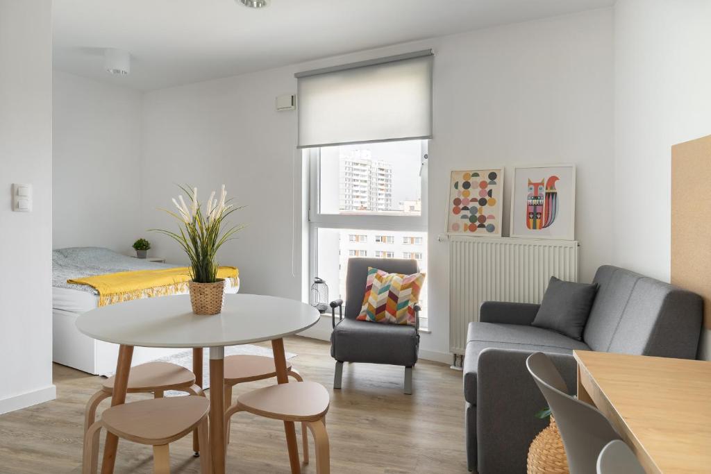 a living room with a table and a couch at Apartamenty Depot Gdańsk in Gdańsk
