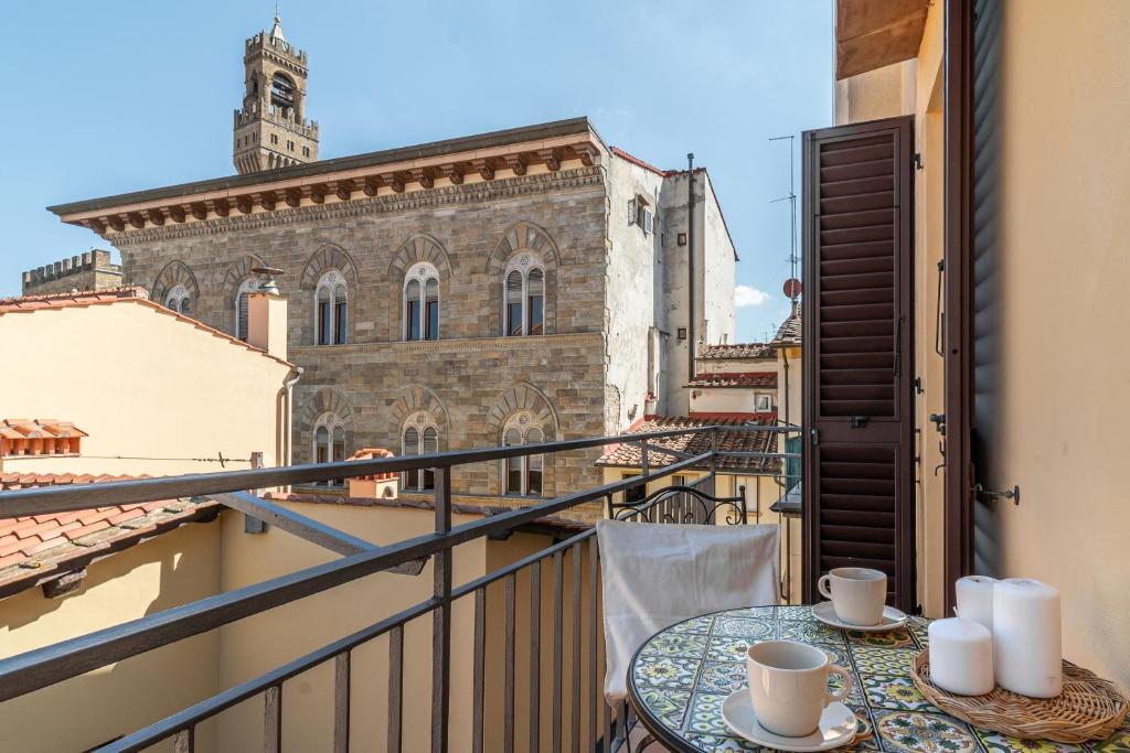 a balcony with two cups of coffee on a table at The Tower Glimpse in Florence
