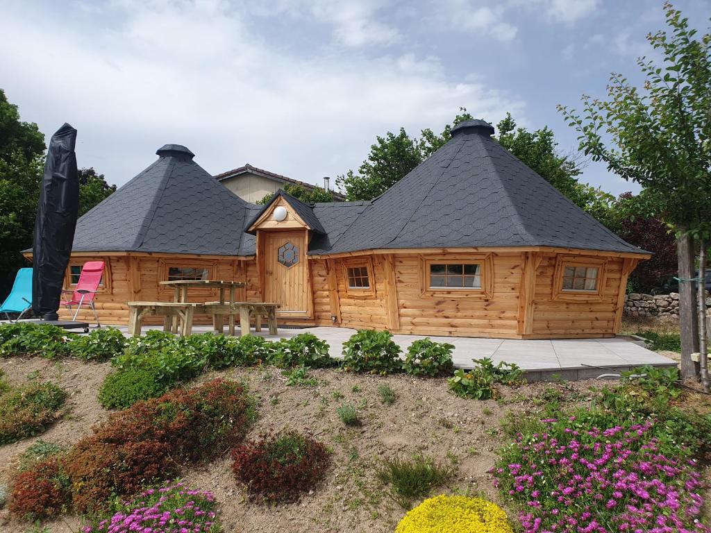 a log cabin with a table and a clock at Kota au Mont des Autruches in Sainte-Sigolène