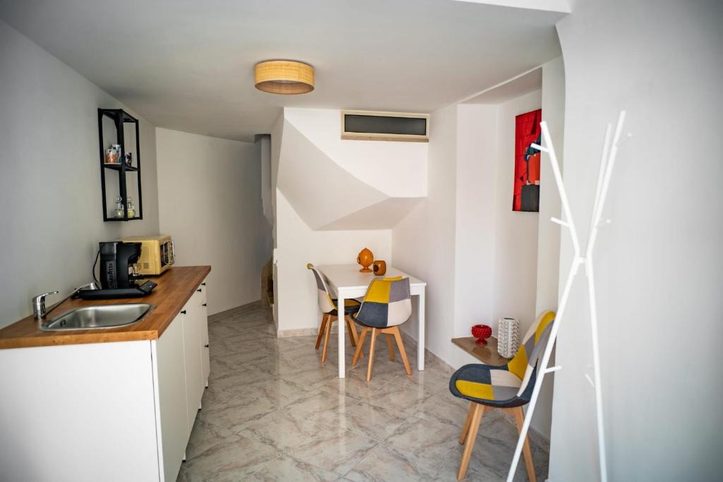 a kitchen with a sink and a table with chairs at Caravigna Love in Carovigno