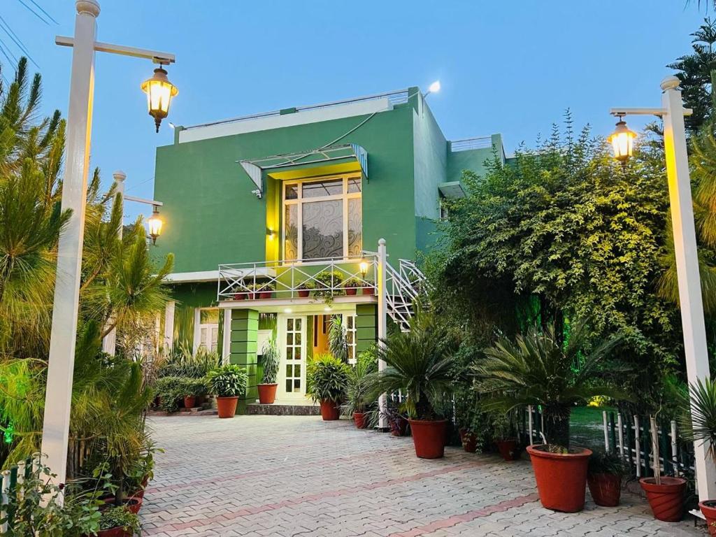 a green house with potted plants in front of it at Hotel green garden in Ludhiana