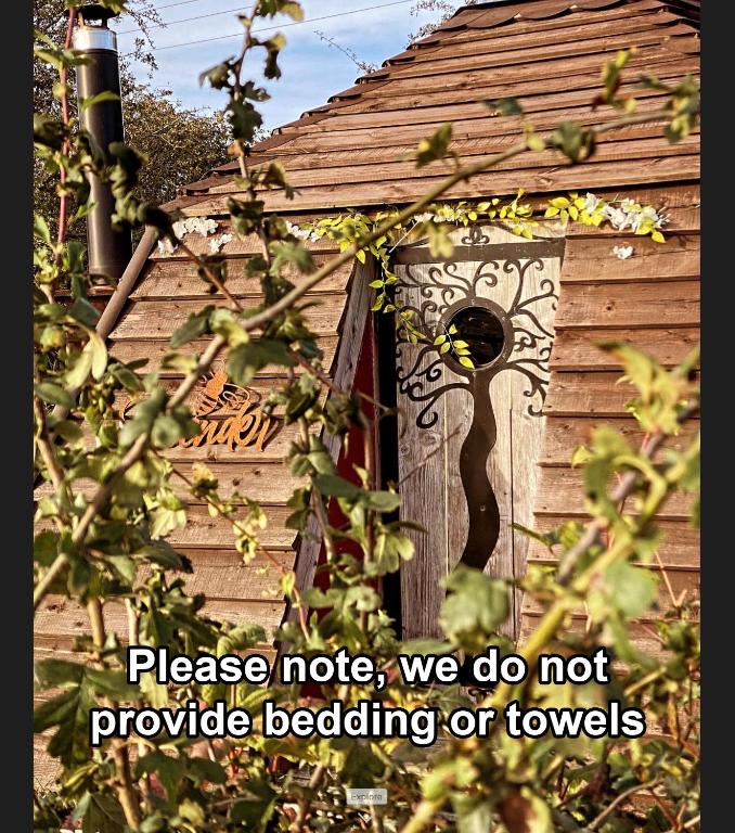 a bird house with a door and a sign on it at daisy meadow in Upton upon Severn