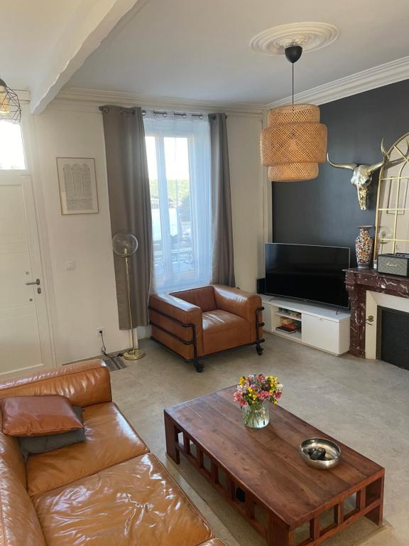 un salon avec un canapé et une table basse dans l'établissement Maison de ville avec jardin, au Mans