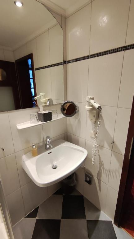 a bathroom with a white sink and a mirror at Familienhotel Sonngastein in Bad Gastein