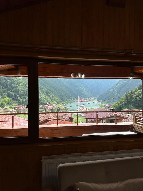 a window with a view of a river and a bridge at Ala Pansiyon in Çaykara