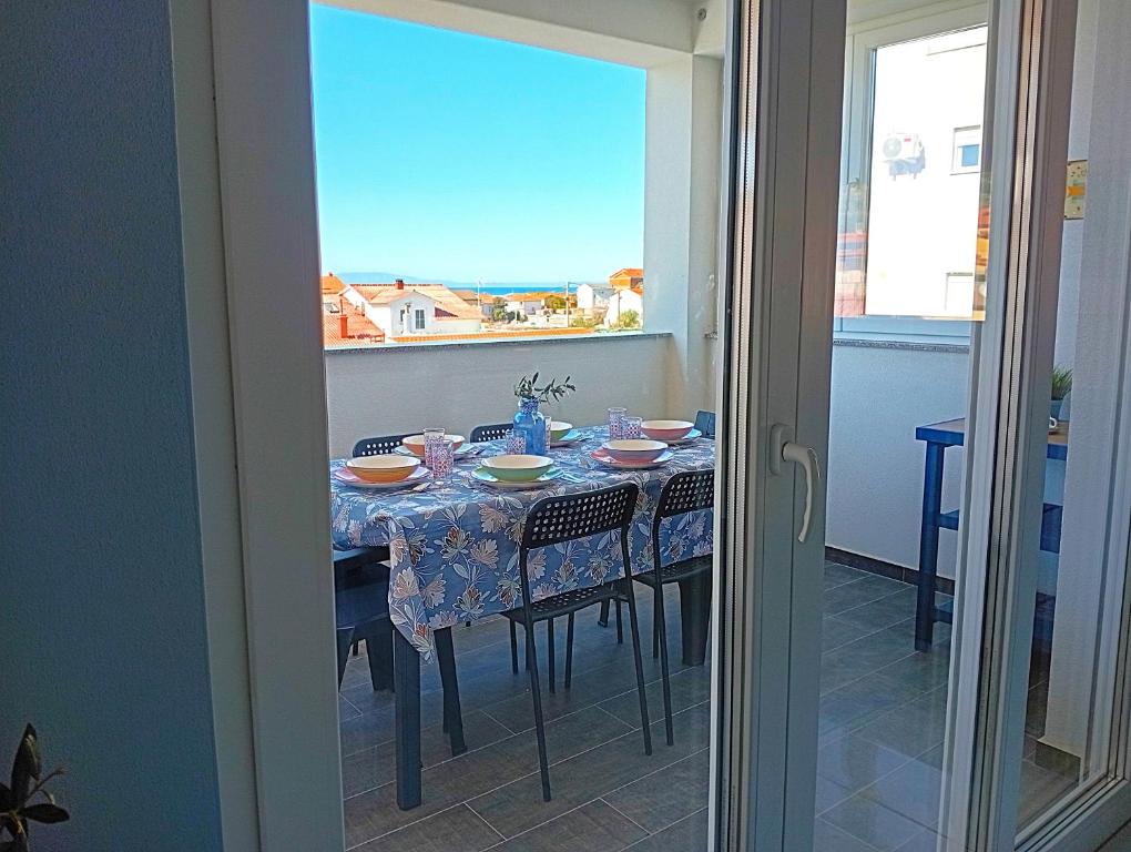 stół jadalny z widokiem na okno w obiekcie Apartment Ivetka w Rabie