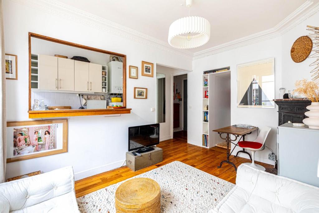 Elle comprend un salon doté d'un mobilier blanc et d'une cheminée. dans l'établissement GuestReady - Charming stay in Chinatown, à Paris