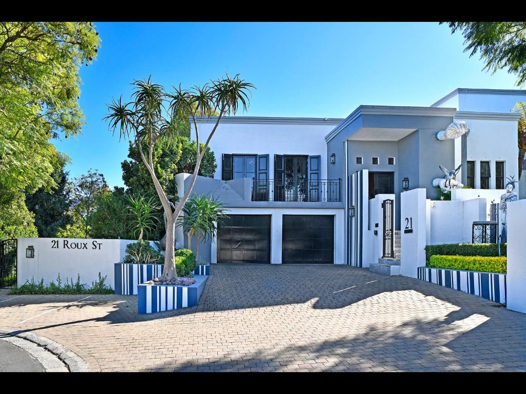 een wit huis met een palmboom ervoor bij Kilima Franschhoek in Franschhoek