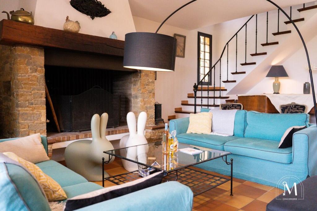 - un salon avec des canapés bleus et une cheminée dans l'établissement Belle demeure dans les hauteurs d'Ollioules, à Ollioules