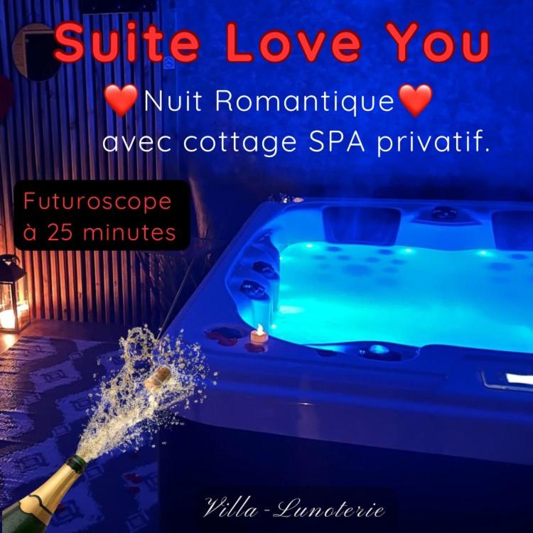 une bouteille de champagne est en train d'être arrosée dans l'établissement Love You Suite Romantique Spa 25min du futuroscope, à Oyré