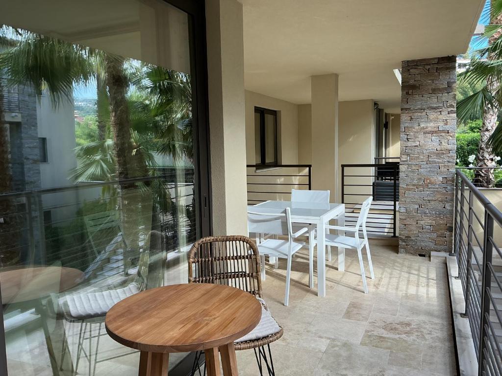 un patio avec une table et des chaises sur un balcon dans l'établissement Les ISSAMBRES, à Roquebrune-sur Argens