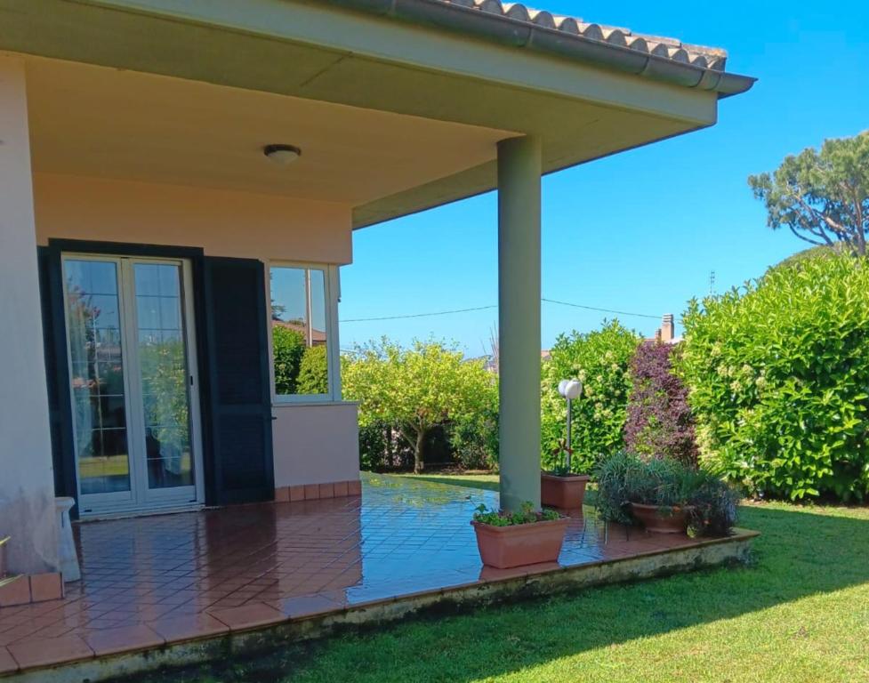 eine Veranda mit Topfpflanzen in der Unterkunft VILLA DAL PESCATORE Apartment - Elegant Retreat between Anzio & Nettuno with Garden and refined Patio - Train Station 500mt in Nettuno