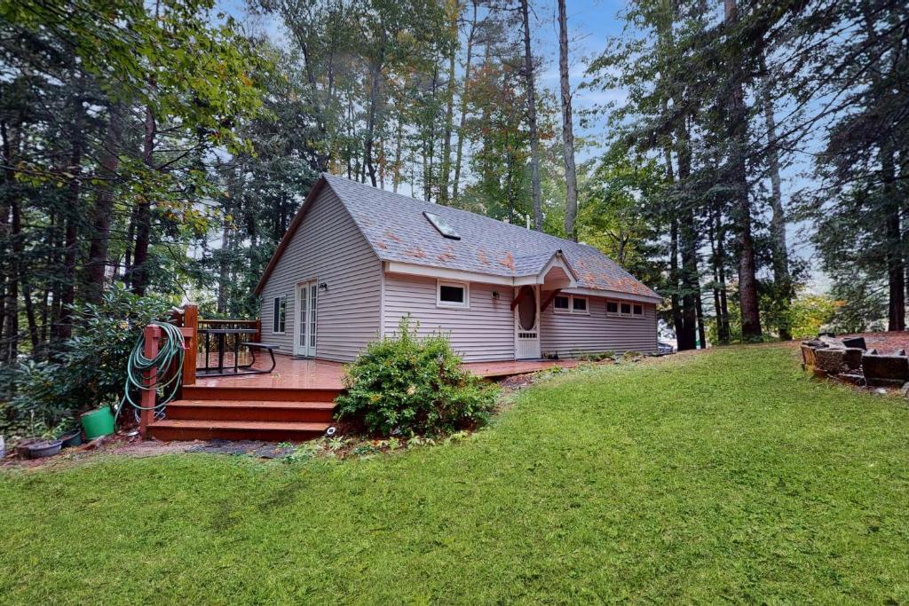 a small house in the middle of a yard at Maine Lake Family Retreat in Monmouth