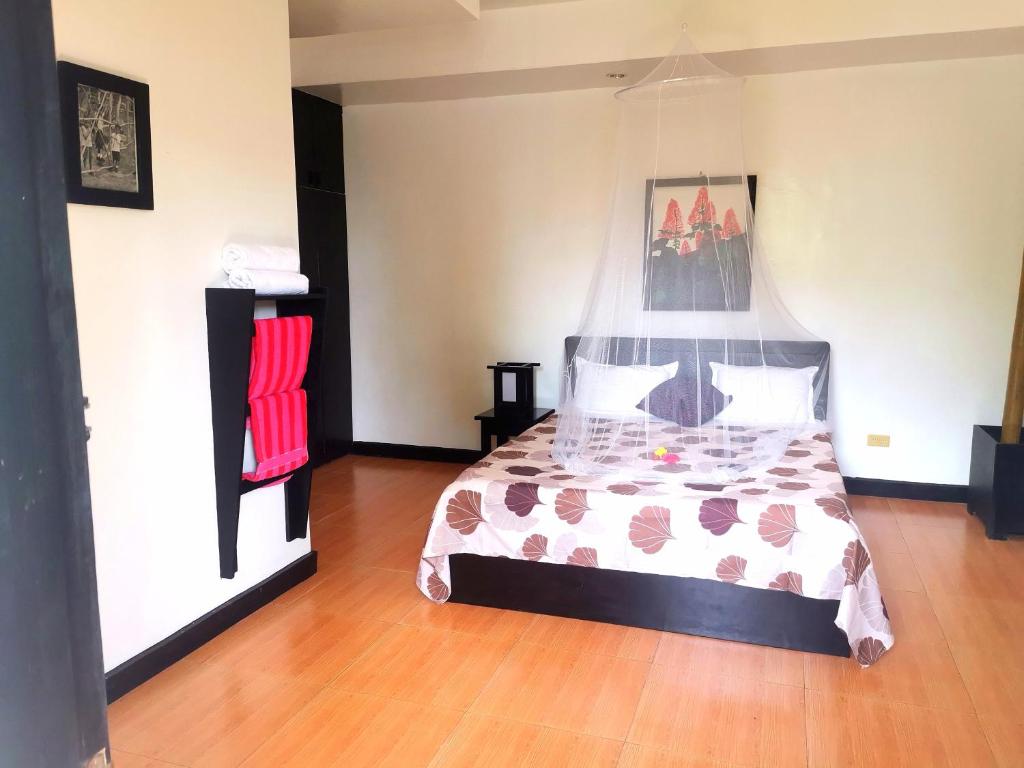 una camera da letto con un letto e un pavimento in legno di La Pernela Resort a Dauis