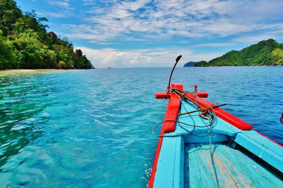 a boat in the water near a island at Sumatra Ecolodge in Sungaipisang