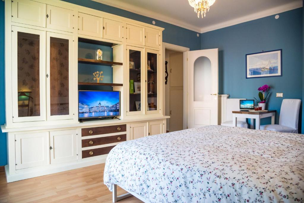 トリエステにあるRoom Feliciaの青い壁のベッドルーム(ベッド1台、テレビ付)