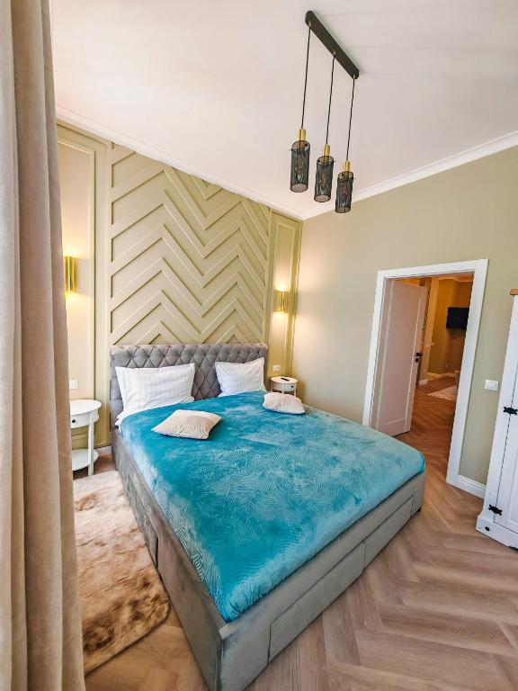 a bedroom with a large blue bed in a room at Olive 1 - w Free Parking, self-checkin, 5 min from Aquapark Nymphaea in Oradea