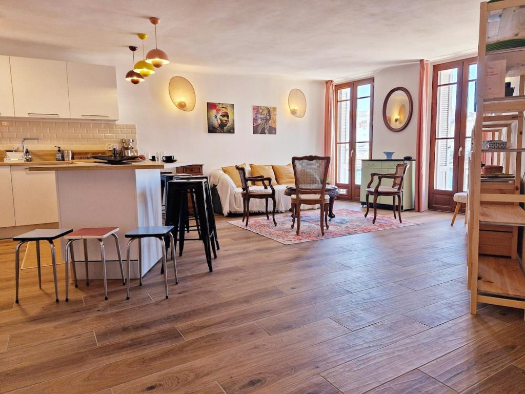 Il comprend une cuisine et un salon avec des chaises et une table. dans l'établissement Le Cosy VIP, un balcon face au Vieux Port, à La Ciotat