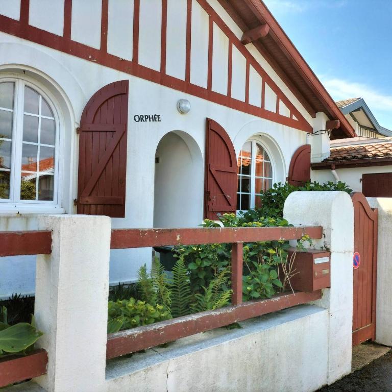 une maison avec des portes brunes et une clôture dans l'établissement Maison Orphée, à La Celle-sous-Gouzon