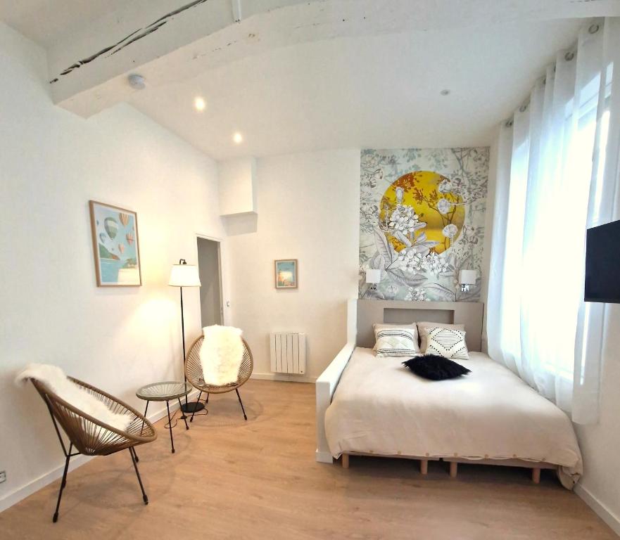 a bedroom with a bed and a table and chairs at Les Bons Enfants Balnéo in Rouen