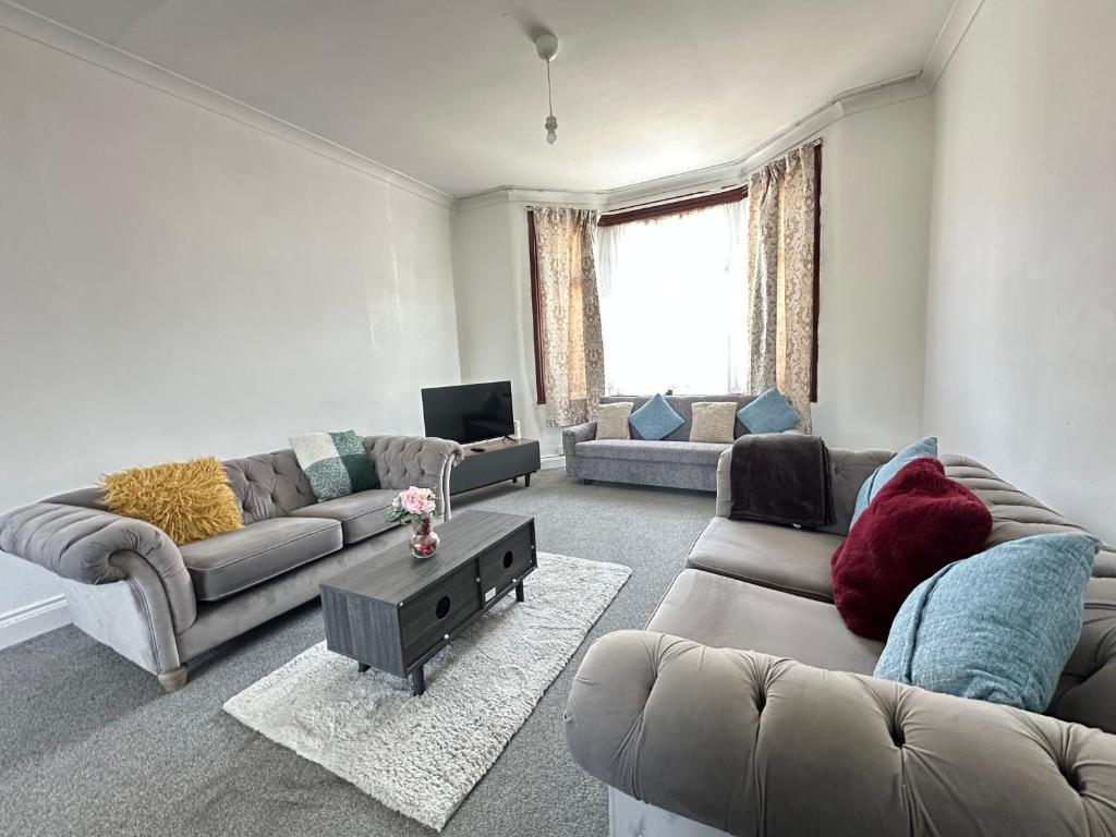 a living room with two couches and a television at Spacious Family Friendly 4-Bed Holiday Home in Ilford